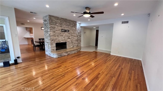 15936 Osborne St, North Hills, CA 91343 - unfurnished living room featuring light wood-style flooring, a ceiling fan, recessed lighting, and a stone fireplace