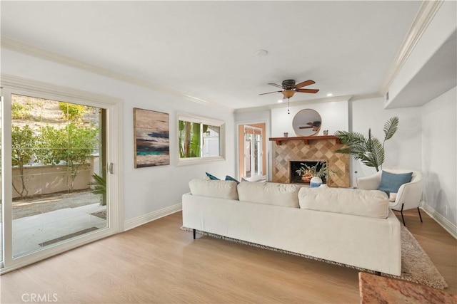 22550 Flamingo St, Woodland Hills, CA 91364 - living room with ornamental molding, light wood-style floors, healthy amount of natural light, a ceiling fan, and a tiled fireplace