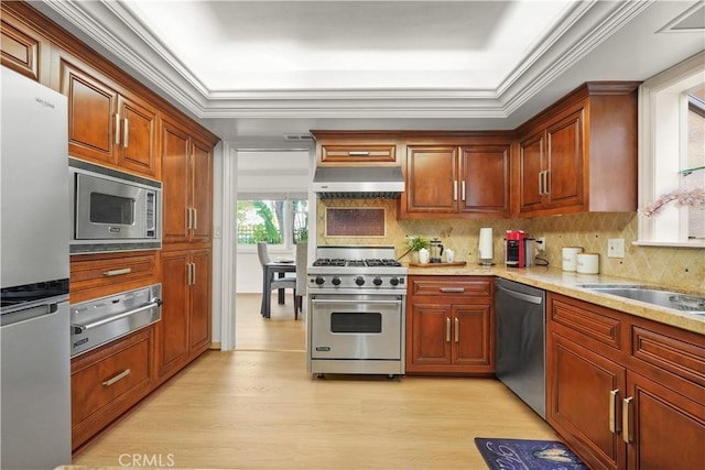 22550 Flamingo St, Woodland Hills, CA 91364 - kitchen featuring appliances with stainless steel finishes, a warming drawer, under cabinet range hood, light wood finished floors, and backsplash