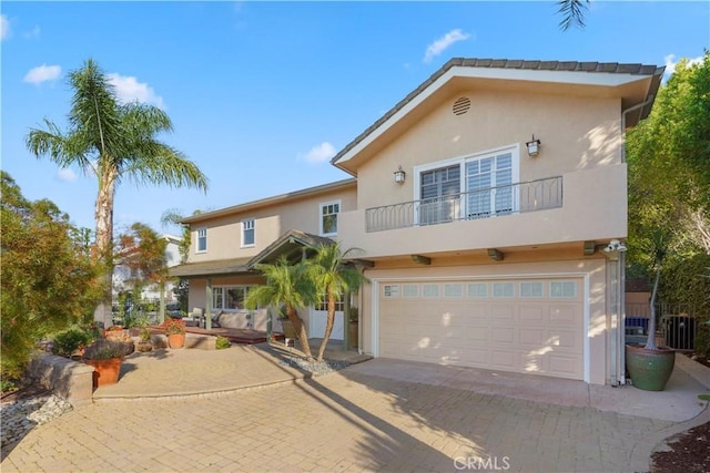 22550 Flamingo St, Woodland Hills, CA 91364 - view of front of home with a balcony, stucco siding, an attached garage, and decorative driveway