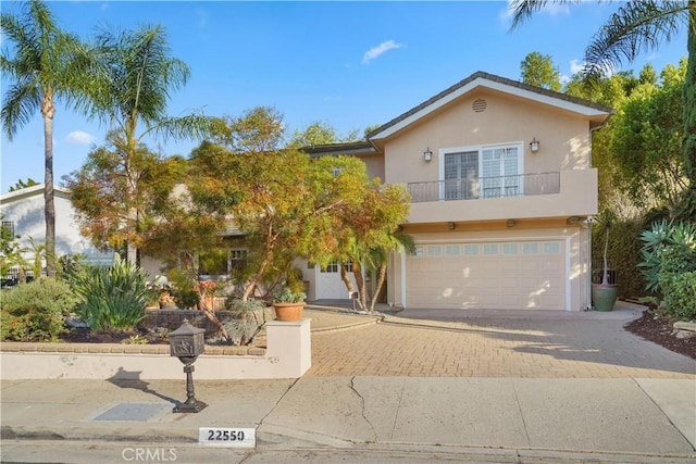 22550 Flamingo St, Woodland Hills, CA 91364 - view of front of property with a balcony, decorative driveway, stucco siding, and an attached garage