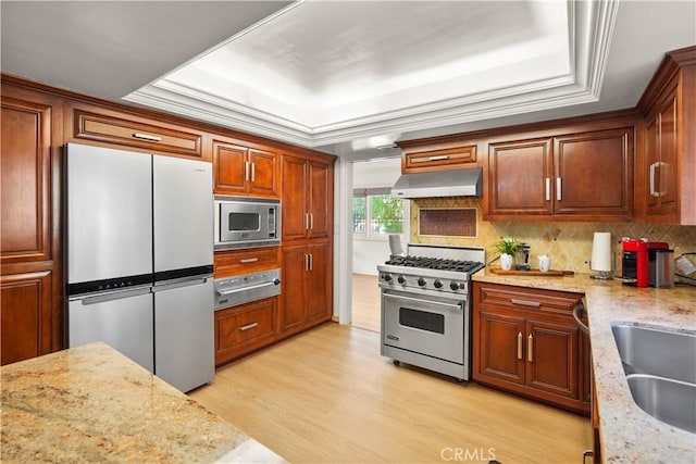 22550 Flamingo St, Woodland Hills, CA 91364 - kitchen with stainless steel appliances, a warming drawer, a tray ceiling, under cabinet range hood, and light wood finished floors