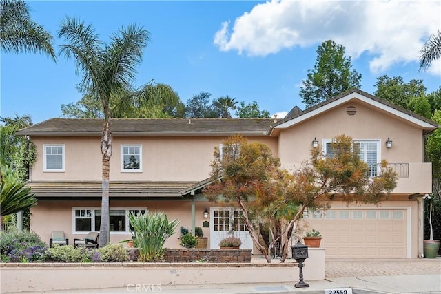22550 Flamingo St, Woodland Hills, CA 91364 - view of front of home featuring stucco siding, an attached garage, and driveway