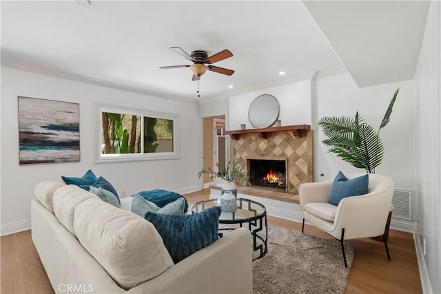 22550 Flamingo St, Woodland Hills, CA 91364 - living area featuring a tiled fireplace, light wood-type flooring, ceiling fan, ornamental molding, and recessed lighting
