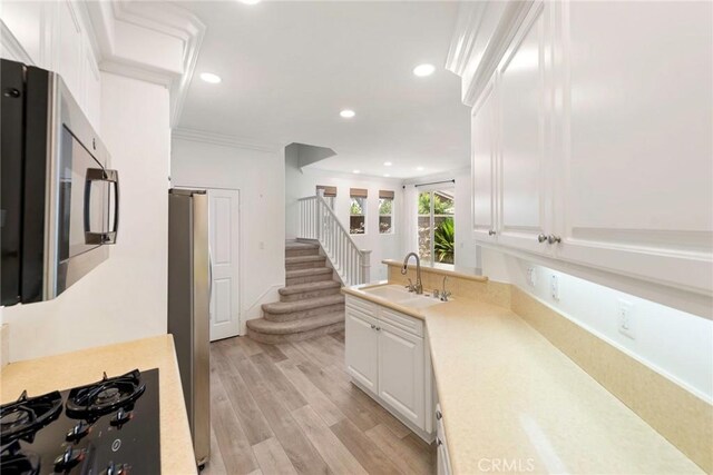 72 Westwind Dr, Tustin, CA 92782 - kitchen with stainless steel appliances, light countertops, white cabinetry, recessed lighting, and light wood-style floors