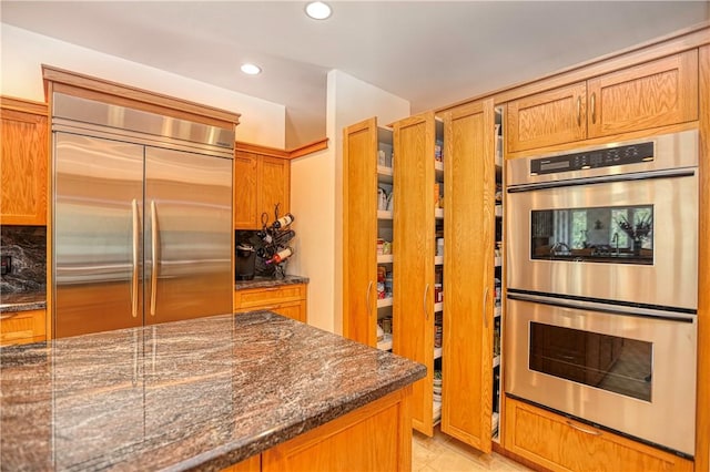 4570 Christine Loomis Dr, Arroyo Grande, CA 93420 - kitchen with appliances with stainless steel finishes, recessed lighting, dark stone countertops, brown cabinets, and decorative backsplash