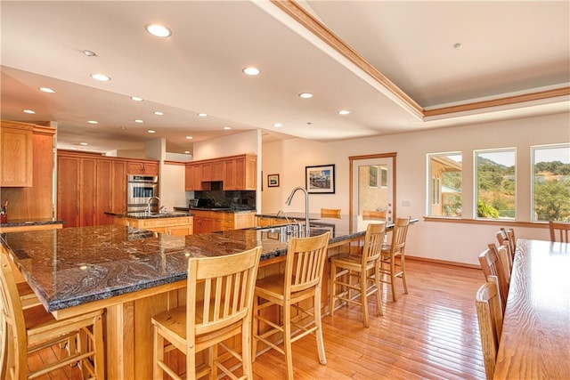4570 Christine Loomis Dr, Arroyo Grande, CA 93420 - kitchen featuring a spacious island, recessed lighting, light wood-style flooring, a kitchen breakfast bar, and decorative backsplash