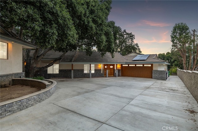 1146 Sandhurst Ln, La Verne, CA 91750 - view of front facade featuring solar panels, stucco siding, an attached garage, and concrete driveway