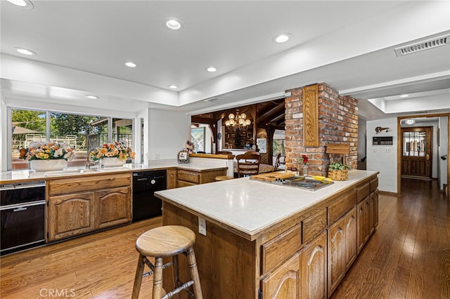 1146 Sandhurst Ln, La Verne, CA 91750 - kitchen with black dishwasher, a tray ceiling, hardwood / wood-style flooring, stainless steel cooktop, and recessed lighting
