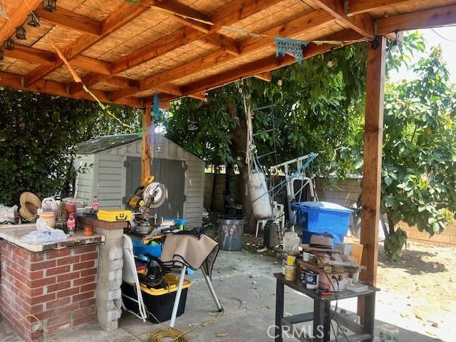 1550 W 21st St, San Bernardino, CA 92411 - fenced backyard featuring a storage shed and a patio