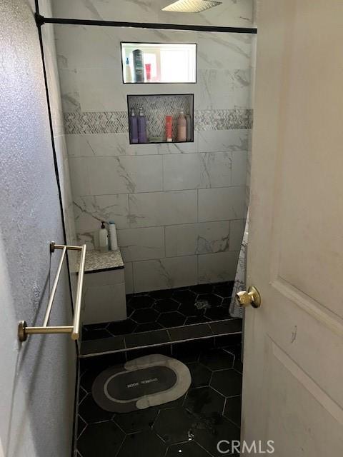 1550 W 21st St, San Bernardino, CA 92411 - bathroom featuring tile patterned floors and a tile shower