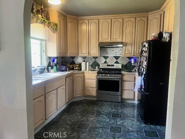 1550 W 21st St, San Bernardino, CA 92411 - kitchen with stainless steel range with gas stovetop, freestanding refrigerator, and light brown cabinets