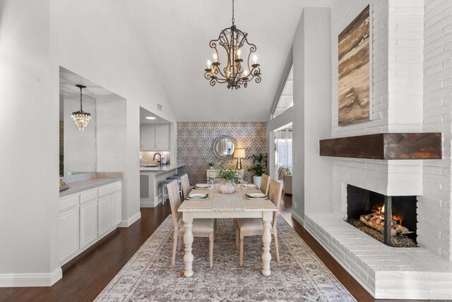 1247 La Casa Dr, San Marcos, CA 92078 - dining space with a chandelier, wallpapered walls, dark wood-type flooring, a brick fireplace, and an accent wall