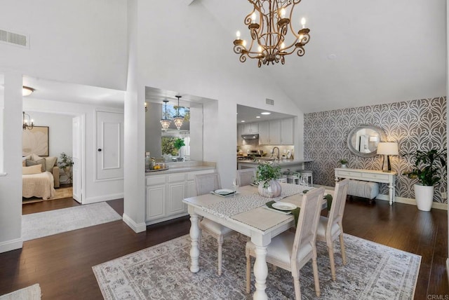 1247 La Casa Dr, San Marcos, CA 92078 - dining room featuring wallpapered walls, a chandelier, dark wood finished floors, an accent wall, and high vaulted ceiling