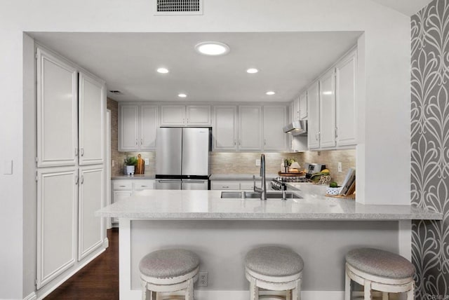 1247 La Casa Dr, San Marcos, CA 92078 - kitchen featuring freestanding refrigerator, stove, a peninsula, white cabinetry, and recessed lighting