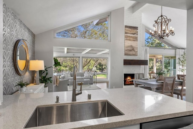 1247 La Casa Dr, San Marcos, CA 92078 - kitchen with a fireplace, high vaulted ceiling, dishwashing machine, light stone countertops, and plenty of natural light