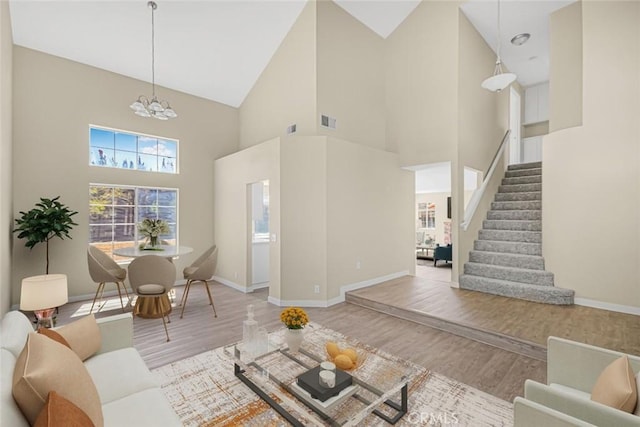 2608 W Oldfield St, Lancaster, CA 93536 - living room featuring wood finished floors, high vaulted ceiling, stairway, and a chandelier
