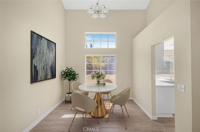 2608 W Oldfield St, Lancaster, CA 93536 - dining area with a chandelier, wood finished floors, and a high ceiling