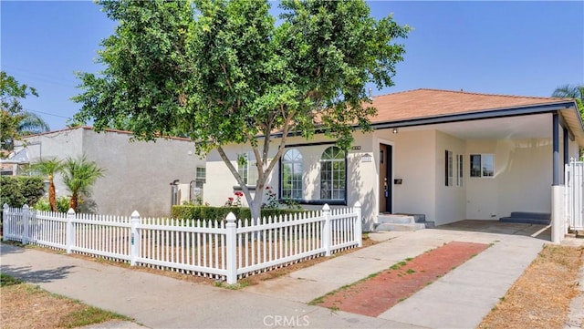 815 N Hagar St, San Fernando, CA 91340 - view of front of home featuring stucco siding, an attached carport, a fenced front yard, and concrete driveway