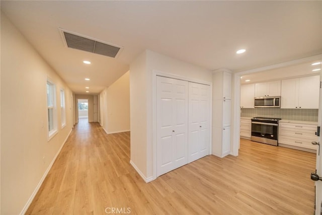 2648 Condor Cir, Corona, CA 92882 - kitchen with appliances with stainless steel finishes, white cabinets, light wood-style flooring, recessed lighting, and backsplash
