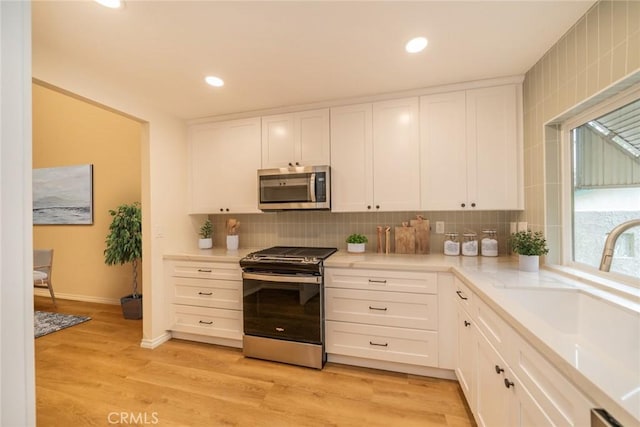 2648 Condor Cir, Corona, CA 92882 - kitchen featuring stainless steel appliances, white cabinetry, backsplash, light countertops, and recessed lighting