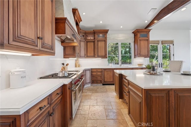 6337 Via Colinita, Rancho Palos Verdes, CA 90275 - kitchen featuring range with two ovens, stone tile floors, custom exhaust hood, recessed lighting, and brown cabinetry