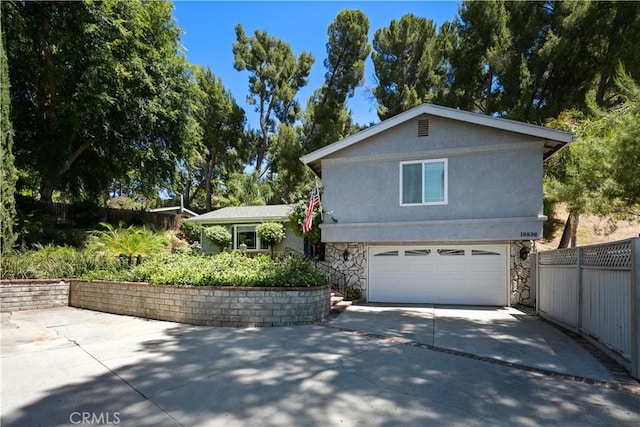 18836 Cedar Valley Way, Newhall, CA 91321 - view of front of home with concrete driveway, stone siding, a garage, and stucco siding