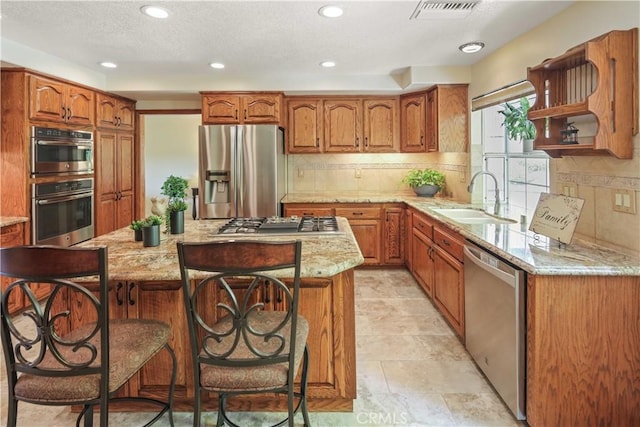 18836 Cedar Valley Way, Newhall, CA 91321 - kitchen with stainless steel appliances, brown cabinets, light stone countertops, a kitchen breakfast bar, and recessed lighting