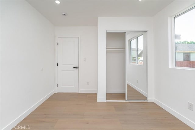 3818 Crawford St, Los Angeles, CA 90011 - unfurnished bedroom featuring multiple windows, light wood-style flooring, recessed lighting, and a closet