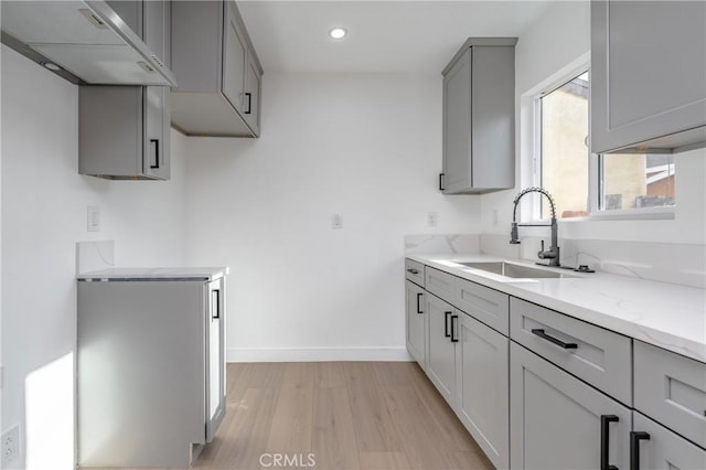 3818 Crawford St, Los Angeles, CA 90011 - kitchen featuring range hood, gray cabinetry, light stone counters, light wood-style flooring, and recessed lighting