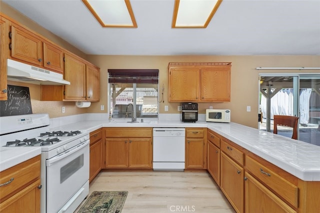 23050 Catt Rd, Wildomar, CA 92595 - kitchen featuring white appliances, under cabinet range hood, a peninsula, and healthy amount of natural light