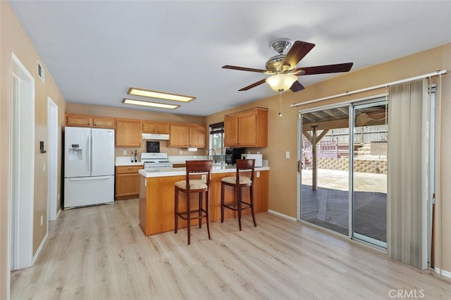 23050 Catt Rd, Wildomar, CA 92595 - kitchen with white fridge with ice dispenser, range, under cabinet range hood, light wood-style floors, and ceiling fan