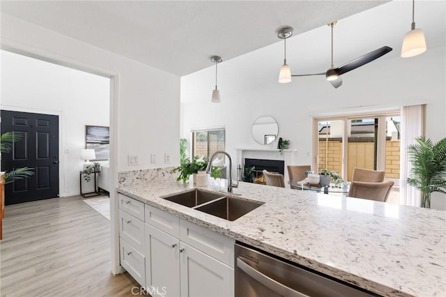 1024 Ardmore Cir, Redlands, CA 92374 - kitchen featuring a fireplace, white cabinets, light wood-style floors, stainless steel dishwasher, and decorative light fixtures