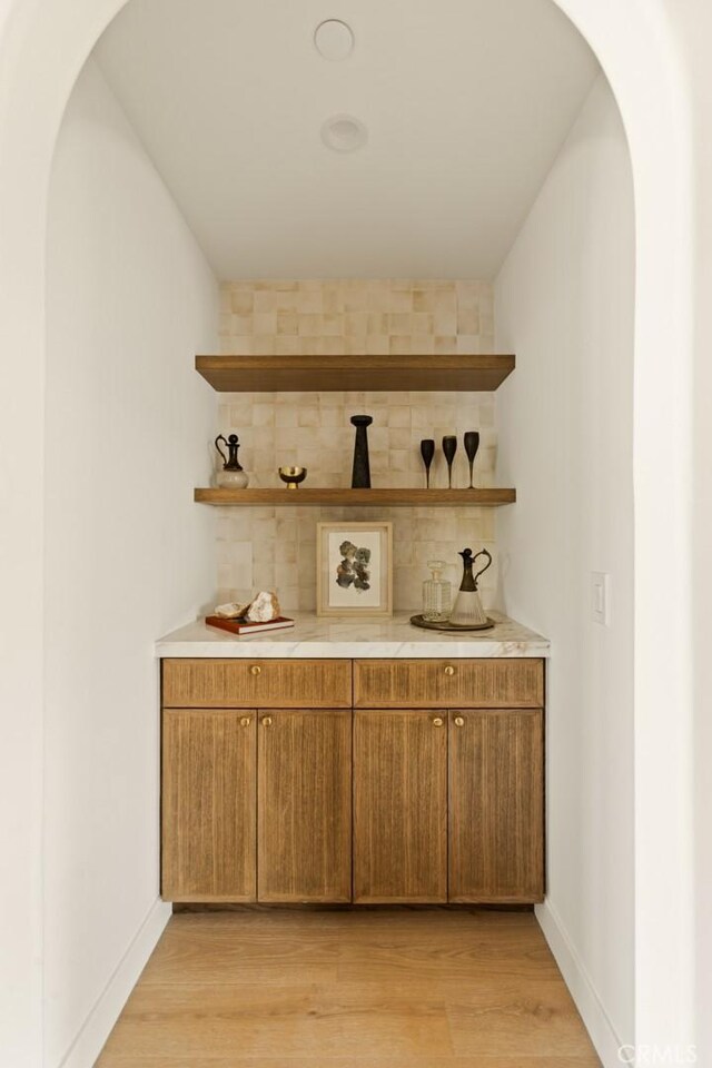 2334 Glover Pl, Los Angeles, CA 90031 - bar featuring arched walkways, decorative backsplash, and light wood finished floors