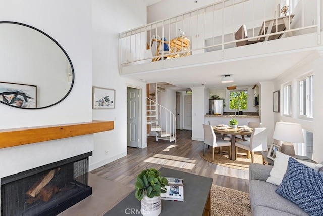 20371 Bluffside Cir Unit B401, Huntington Beach, CA 92646 - living area featuring stairs, wood finished floors, a high ceiling, and a multi sided fireplace