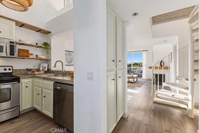 20371 Bluffside Cir Unit B401, Huntington Beach, CA 92646 - kitchen with appliances with stainless steel finishes, wood finished floors, open shelves, dark stone countertops, and a towering ceiling