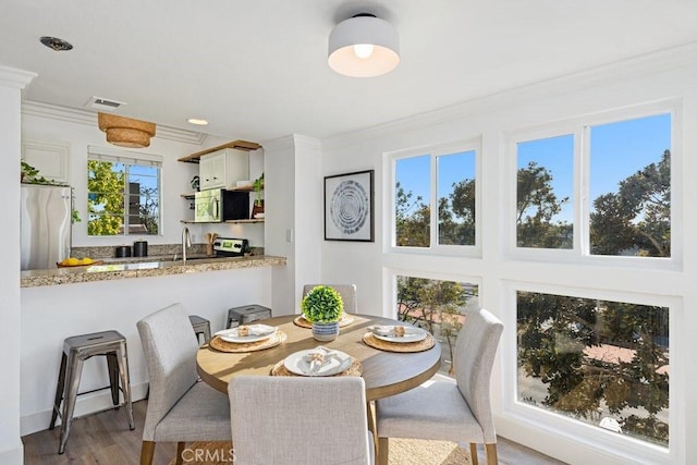 20371 Bluffside Cir Unit B401, Huntington Beach, CA 92646 - dining area featuring crown molding and wood finished floors