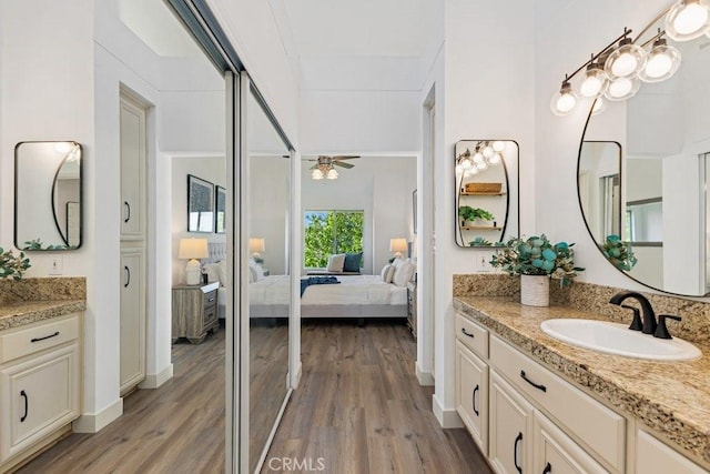 20371 Bluffside Cir Unit B401, Huntington Beach, CA 92646 - ensuite bathroom featuring two vanities, wood finished floors, and a ceiling fan