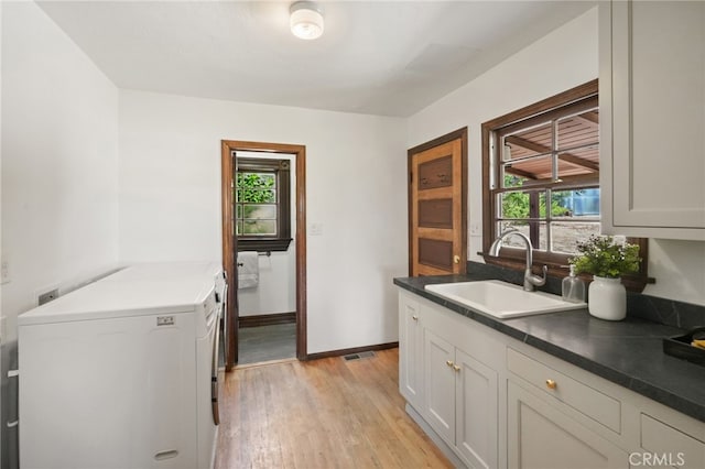 10821 Los Jordans Rd, Agua Dulce, CA 91390 - washroom featuring cabinet space, washing machine and clothes dryer, plenty of natural light, and light wood-style flooring