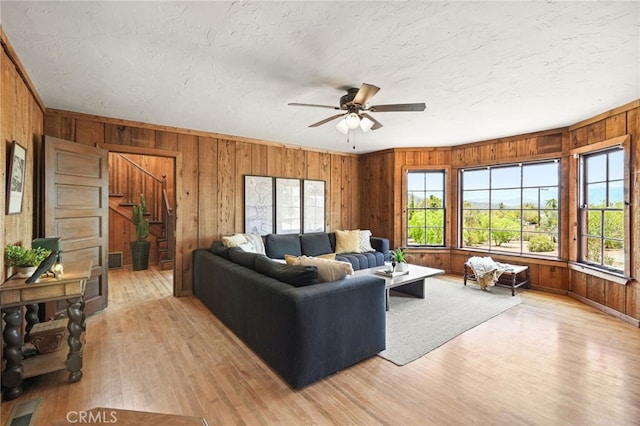10821 Los Jordans Rd, Agua Dulce, CA 91390 - living area featuring wooden walls, light wood finished floors, ceiling fan, stairway, and a textured ceiling