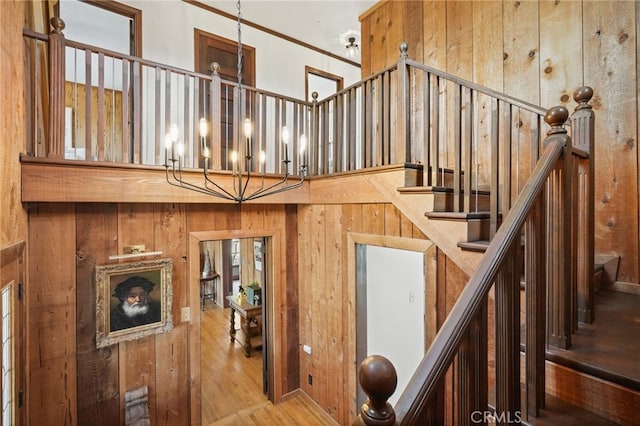 10821 Los Jordans Rd, Agua Dulce, CA 91390 - stairway featuring wood finished floors, wooden walls, a chandelier, and crown molding