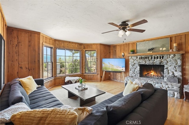 10821 Los Jordans Rd, Agua Dulce, CA 91390 - living room with wooden walls, ceiling fan, light wood-style flooring, and a fireplace