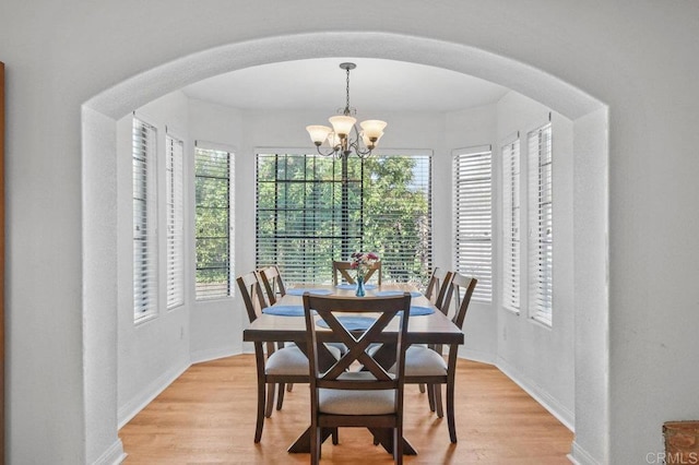 5855 Kappa St, La Mesa, CA 91942 - dining room featuring a chandelier, arched walkways, and light wood-style floors