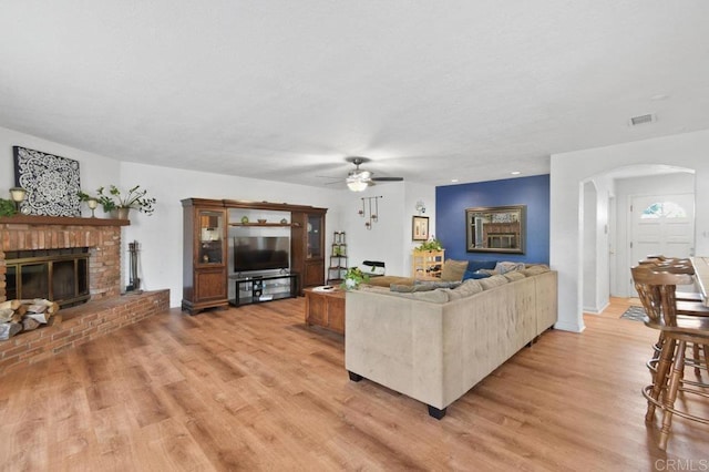 5855 Kappa St, La Mesa, CA 91942 - living area with a fireplace, arched walkways, a ceiling fan, and light wood-style floors