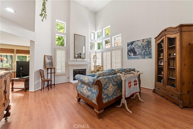 762 Twin Peaks Ave, Simi Valley, CA 93065 - living room with light wood-style flooring, a high ceiling, and a brick fireplace