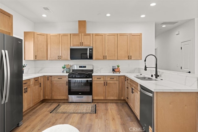 6105 Maxwood Dr, Paradise, CA 95969 - kitchen featuring stainless steel appliances, a peninsula, light wood-type flooring, light stone countertops, and recessed lighting