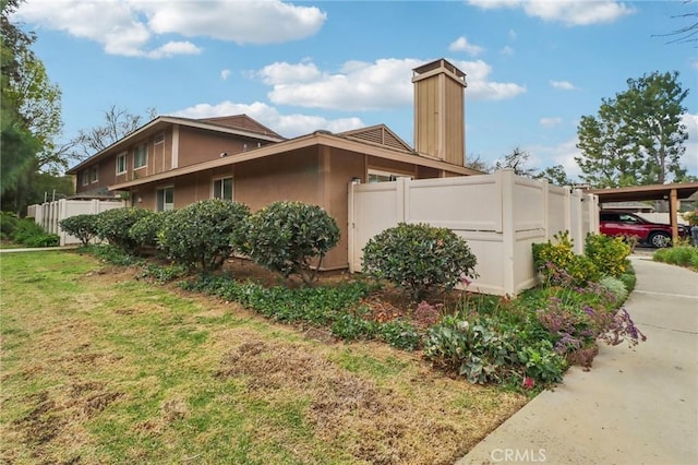 28512 Conejo View Dr, Agoura Hills, CA 91301 - view of side of home featuring a chimney, stucco siding, and a carport