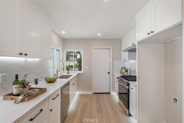 14 Willow Tree Ln, Irvine, CA 92612 - kitchen with appliances with stainless steel finishes, under cabinet range hood, light wood-style floors, white cabinets, and recessed lighting