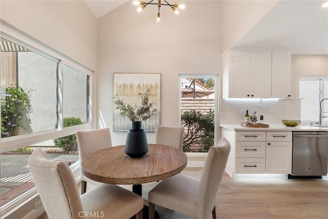 14 Willow Tree Ln, Irvine, CA 92612 - dining area with a chandelier, light wood-style flooring, and high vaulted ceiling