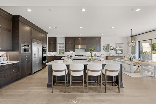 19818 Cornell Ln, Yorba Linda, CA 92886 - kitchen featuring stainless steel appliances, recessed lighting, light countertops, dark brown cabinetry, and under cabinet range hood